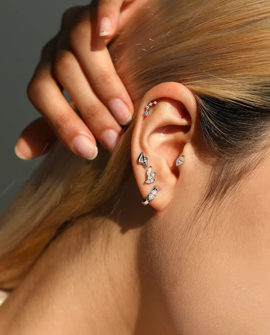 Stiftörhängen Formade som en Spiralsnäcka i 925 Sterlingsilver - buret av en modell med handen bakom huvudet
