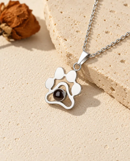 Personligt tasshalsband i 925 sterlingsilver med bild inuti, upplagt på ett block av travertin