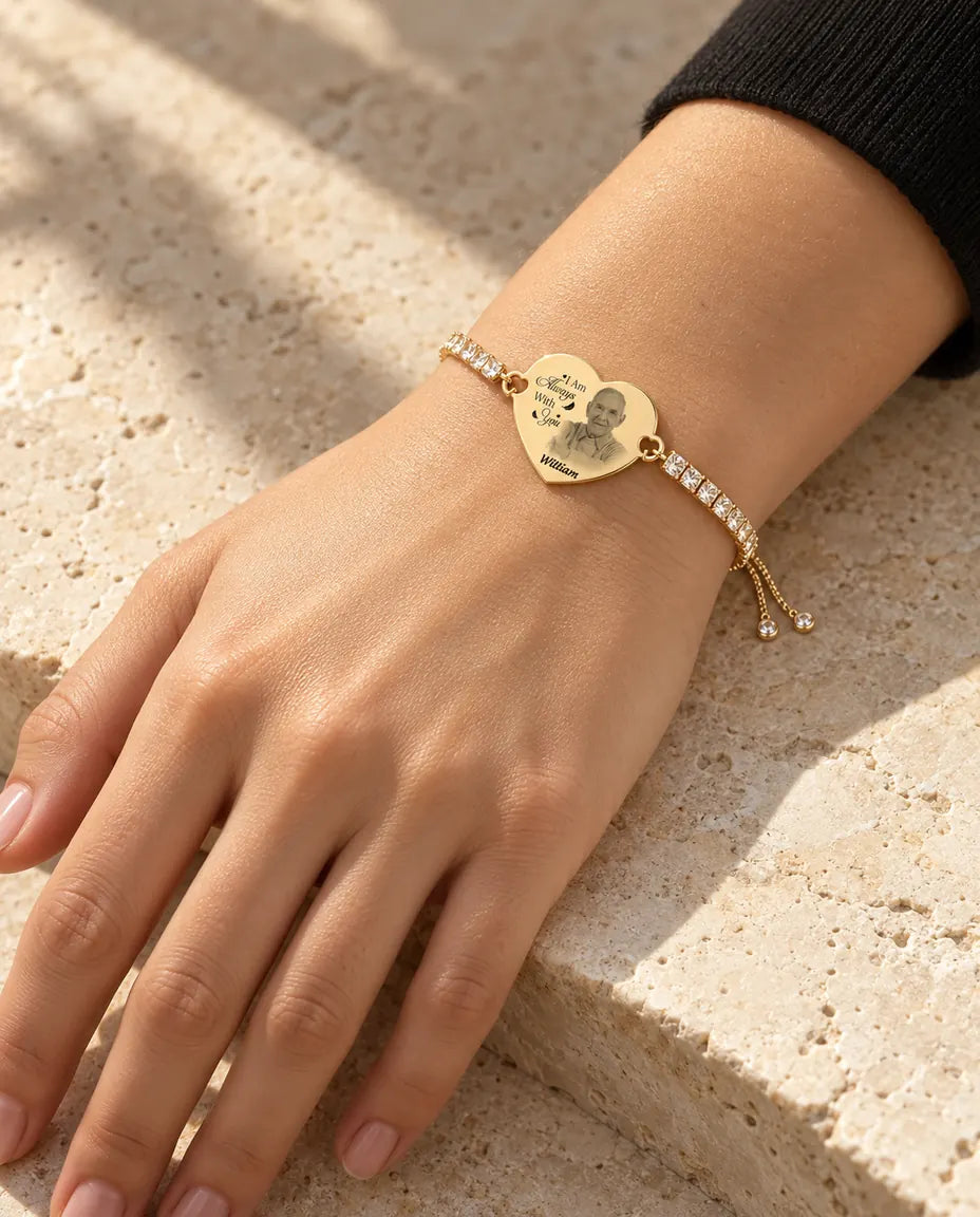 Kvinna som bär det guldfärgade tennisarmbandet med graverat hjärta och bild