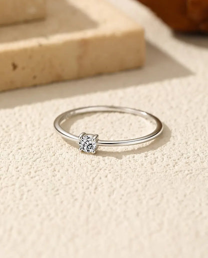 Moissanite Ring i 925 Sterlingsilver - liggande på en ljus strukturerad yta