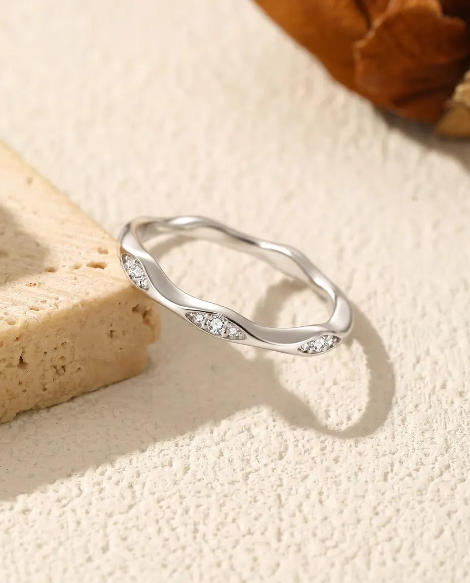 Vågig Moissanite Ring i 925 Sterlingsilver - på kanten av en travertinplatta