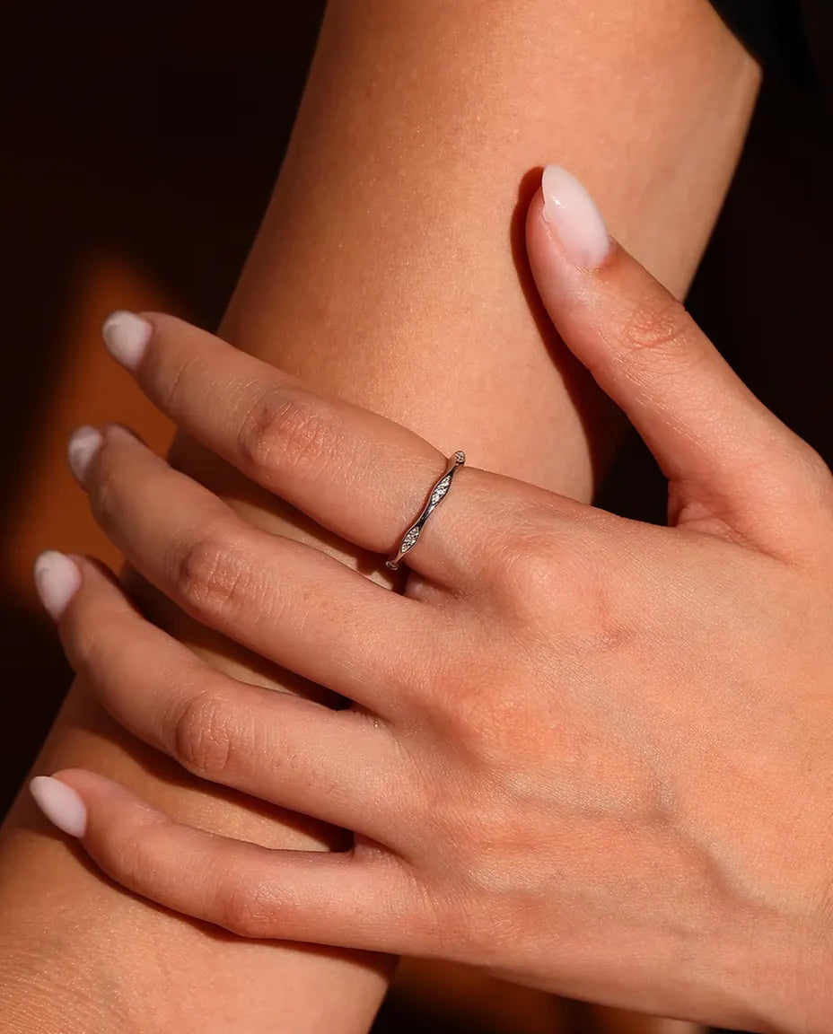 Vågig Moissanite Ring i 925 Sterlingsilver - buren på en modells finger, närbild
