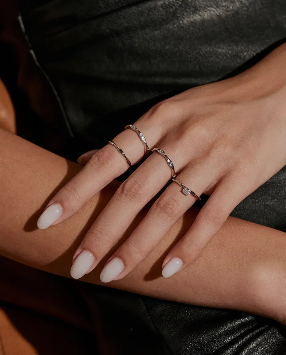Vågig Moissanite Ring i 925 Sterlingsilver - buren tillsammans med andra ringar, händerna på varandra