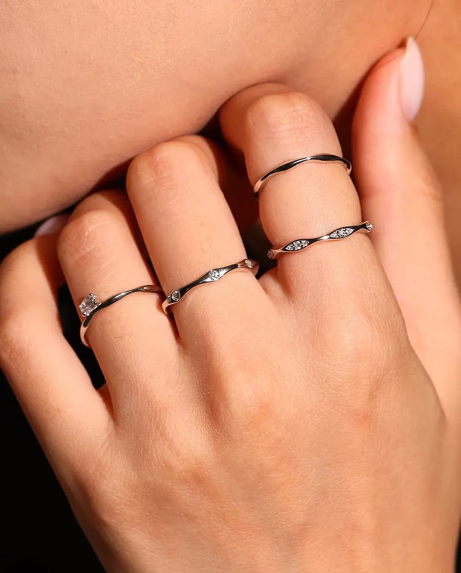 Vågig Moissanite Ring i 925 Sterlingsilver - buren med andra ringar, närbild av fingrarna