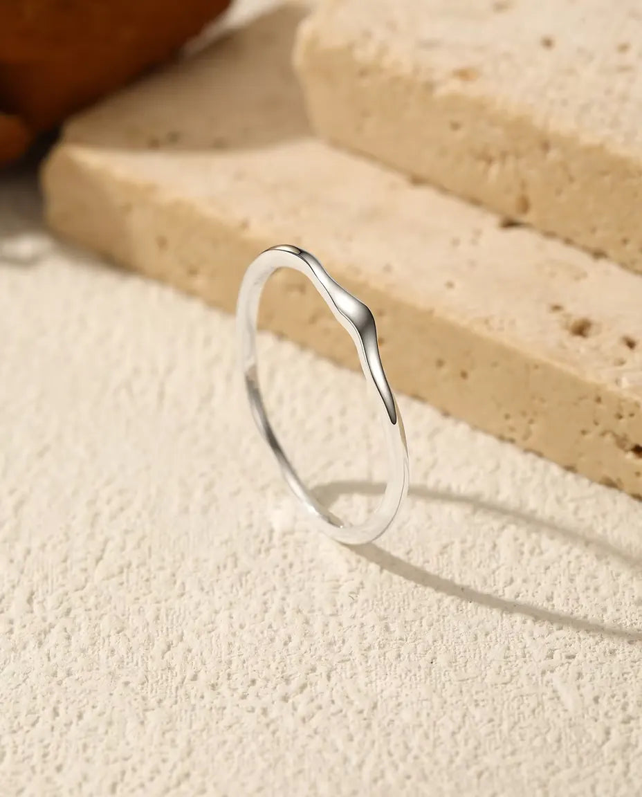Vågig Stapelbar Ring i 925 Sterlingsilver - stående på en ljus strukturerad yta